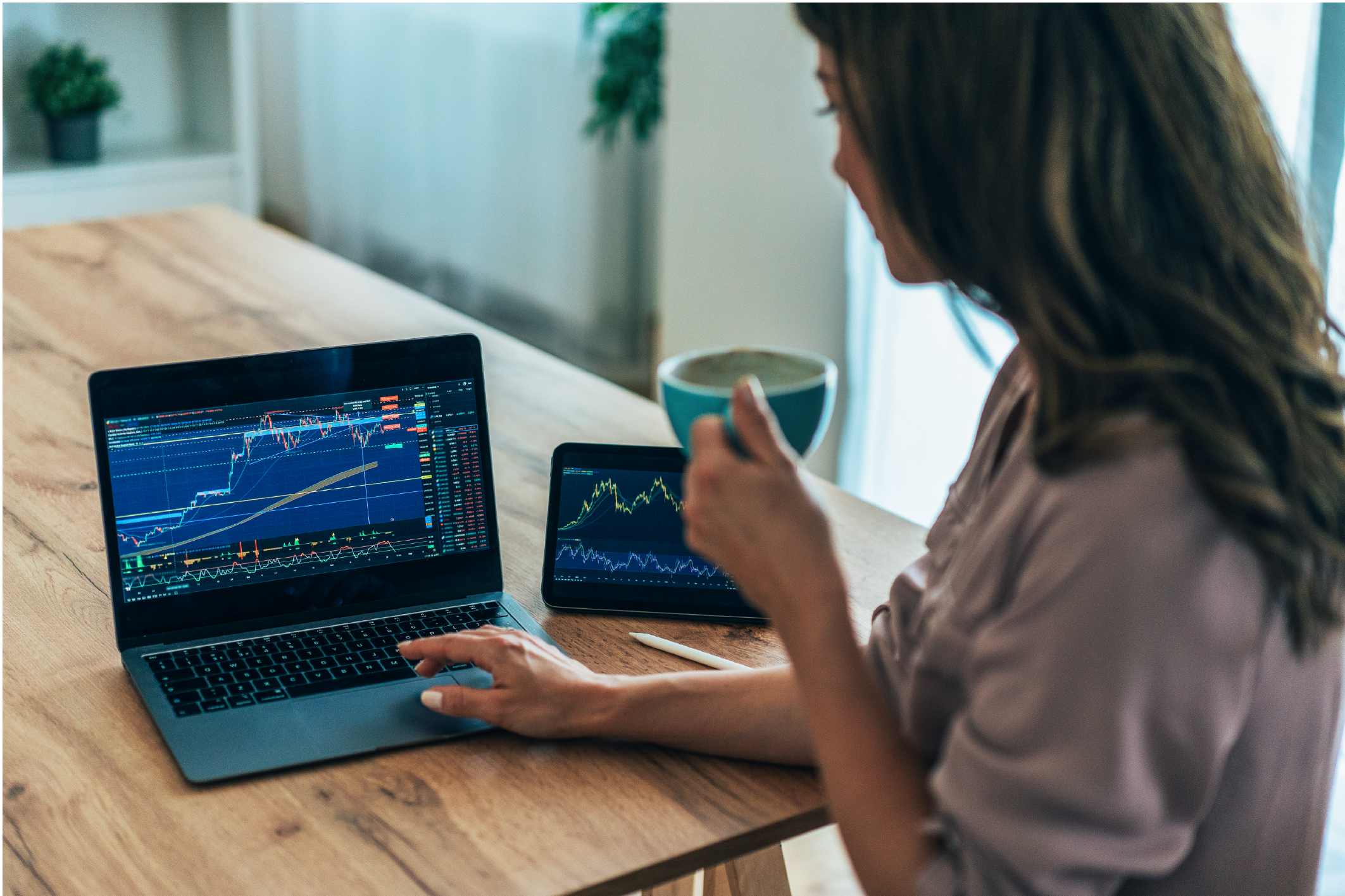woman-analysis-charts Woman analyzing financial charts on a laptop and a tablet